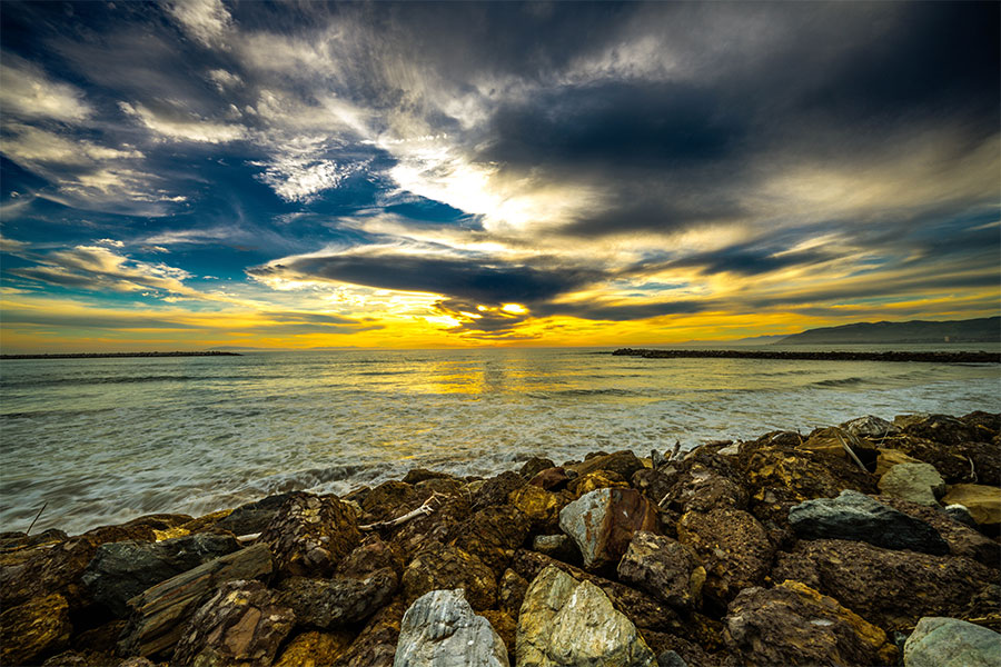 California sunset photography with dramatic sky and coastal rocks